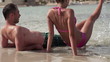 Young couple sitting on the beach, super slow motion