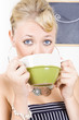 Attractive blonde woman drinking green tea