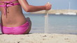 Sexy woman sitting on the beach, super slow motion