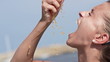 Woman squeeze juicy orange outdoors, slow motion