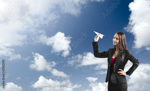 Photo: Business woman throwing a paper plane Business woman throwing a paper plane