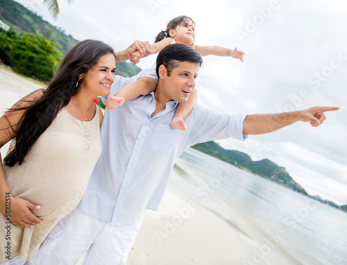 Photo: Family at the beach pointing away Family at the beach pointing away