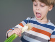 Funny kid holding leek vegetable, refusing to eat