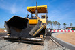 Tracked paver laying fresh asphalt pavement