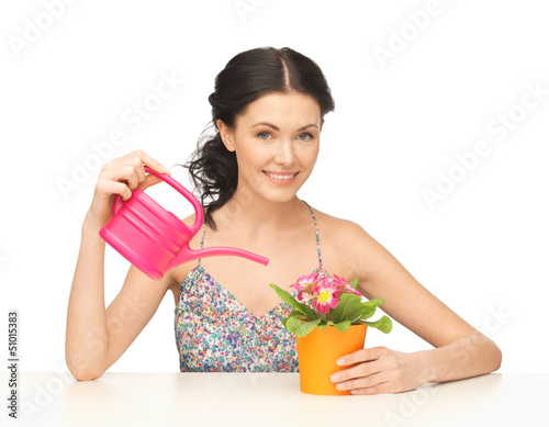 Photo: housewife with flower in pot and watering can housewife with flower in pot and watering can