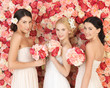 three women with background full of roses