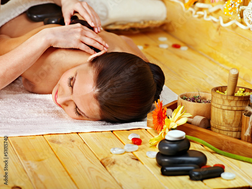 Photo: Woman getting stone therapy massage . Woman getting stone therapy massage .