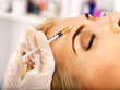 Photo: Woman giving botox injections. Woman giving botox injections.