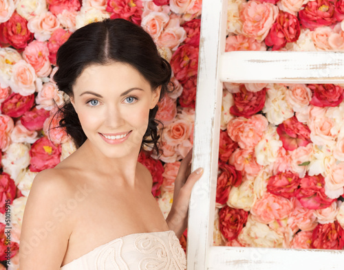 Photo: woman with old ladder and background full of roses woman with old ladder and background full of roses