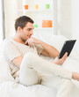 man sitting on the couch with tablet pc