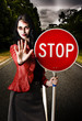 Zombie girl holding stop sign at dead end
