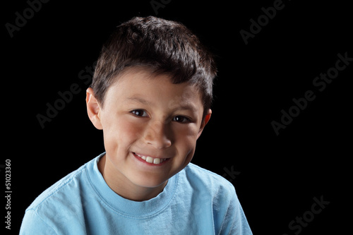 Photo: Smiling boy on black background with dramatic side lighting Smiling boy on black background with dramatic side lighting