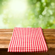 Empty wooden table with tablecloth over bokeh background