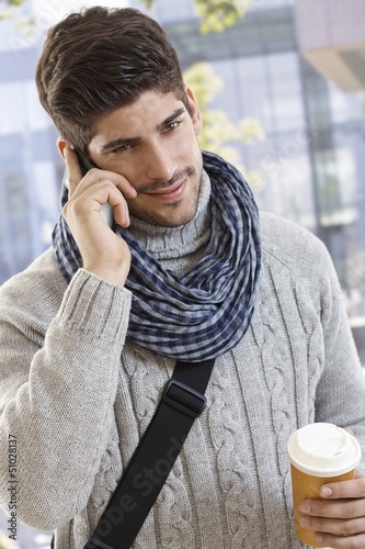 Photo: Happy young man talking on mobile outdoors Happy young man talking on mobile outdoors