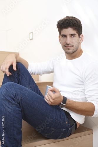 Photo: Daydreaming handsome man sitting on stairs Daydreaming handsome man sitting on stairs