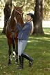 Female rider embracing horse