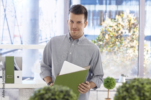 Photo: Portrait of casual office worker with folder Portrait of casual office worker with folder