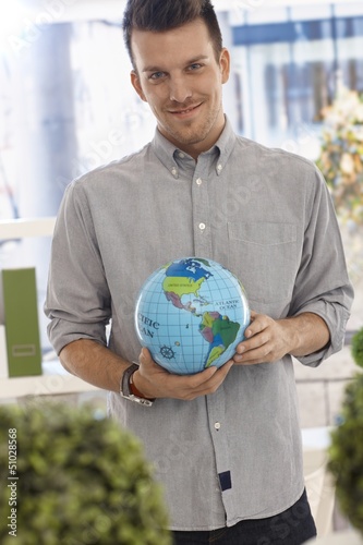Photo: Happy man holding small globe Happy man holding small globe