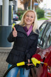 Frau beim tanken auf Tankstelle