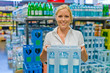 Frau kauft Mineralwasser im Supermarkt