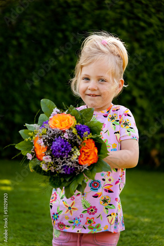 Photo: Kind mit Blumenstrauß. Geschenk für Muttertag Kind mit Blumenstrauß. Geschenk für Muttertag
