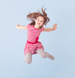 Photo: cheerful girl jumping on a blue background cheerful girl jumping on a blue background