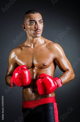 Photo: Boxer with red gloves in dark room Boxer with red gloves in dark room