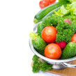 fresh vegetables in metal colander isolated on white