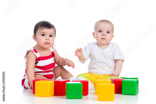 Photo: two babies or kids playing together with color toys two babies or kids playing together with color toys