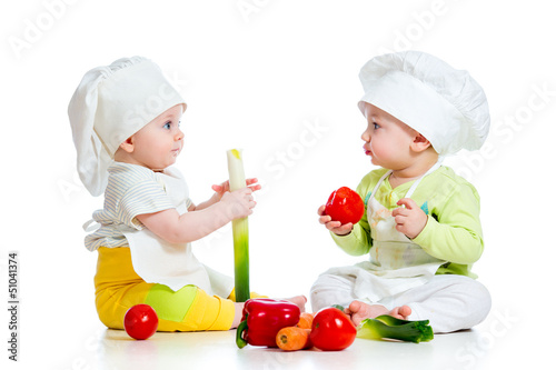 Photo: babies boy and girl wearing a chef hat with healthy food vegeta babies boy and girl wearing a chef hat with healthy food vegeta