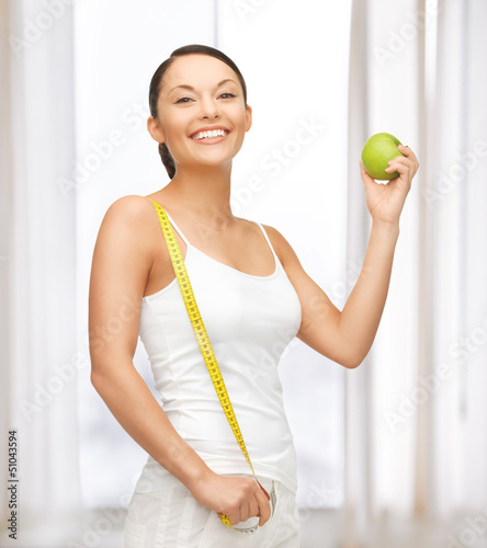 Photo: sporty woman with apple and measuring tape sporty woman with apple and measuring tape
