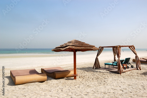 Photo: Beach with hut and sunbeds of the luxury hotel, Ajman, UAE Beach with hut and sunbeds of the luxury hotel, Ajman, UAE