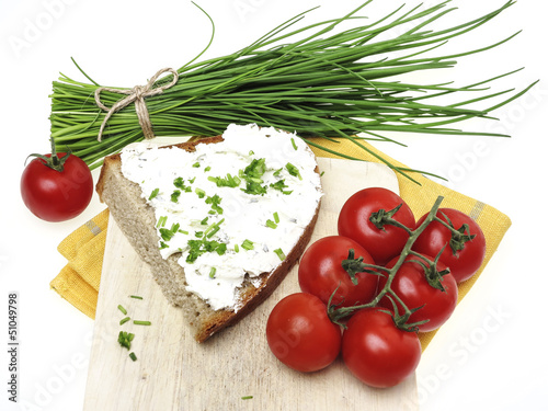 Photo: a slice of bread with cheese and chives on white background a slice of bread with cheese and chives on white background