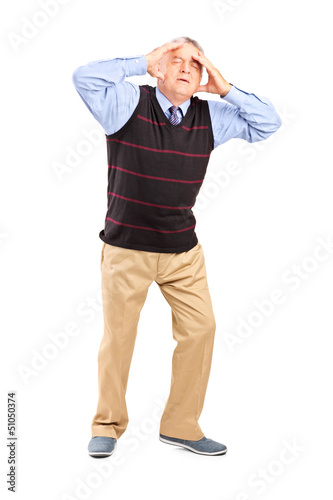 Photo: Full length portrait of a mature man holding his head in pain Full length portrait of a mature man holding his head in pain