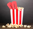 popcorn with tickets on wooden table on grey background