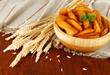 Appetizing village potatoes in bowl on wooden table close-up