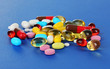 Assortment of pills, tablets and capsules on blue background