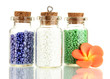 Little bottles full with colorful beads isolated on white