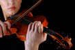 Musician playing violin on black background