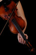 Musician playing violin on black background