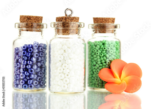 Photo: Little bottles full with colorful beads isolated on white Little bottles full with colorful beads isolated on white