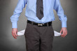 Business man showing his empty pockets, on grey background