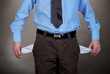 Business man showing his empty pockets, on grey background