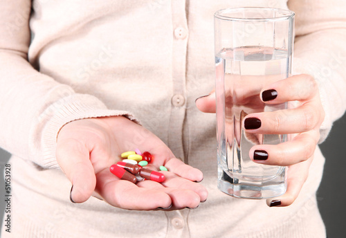 Photo: Many pills and glass water in hand Many pills and glass water in hand