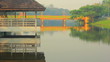 an old wooden pavilion with reflections on a lake