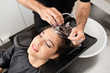 Hairdressers Hand Washing Customer's Hair