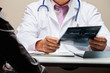 Radiologist At Desk Holding X-ray