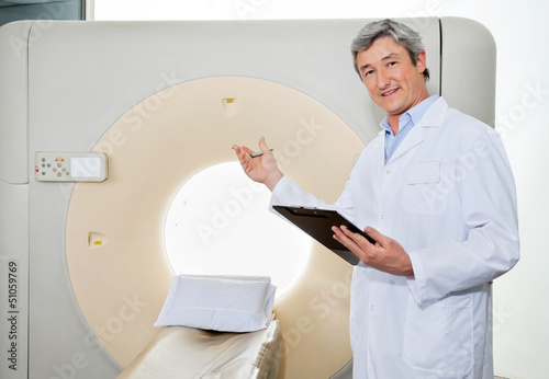 Photo: Male Doctor Presenting The CT Scan Machine Male Doctor Presenting The CT Scan Machine