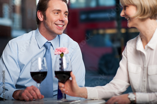 Photo: Happy couple drinking red wine at a restaurant Happy couple drinking red wine at a restaurant