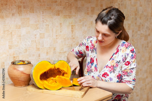 Photo: woman cuts pumpkin woman cuts pumpkin